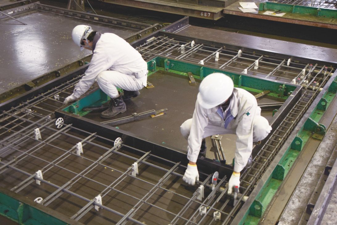 カゴ状態に組み上げた鉄筋を型枠内にセッティング 