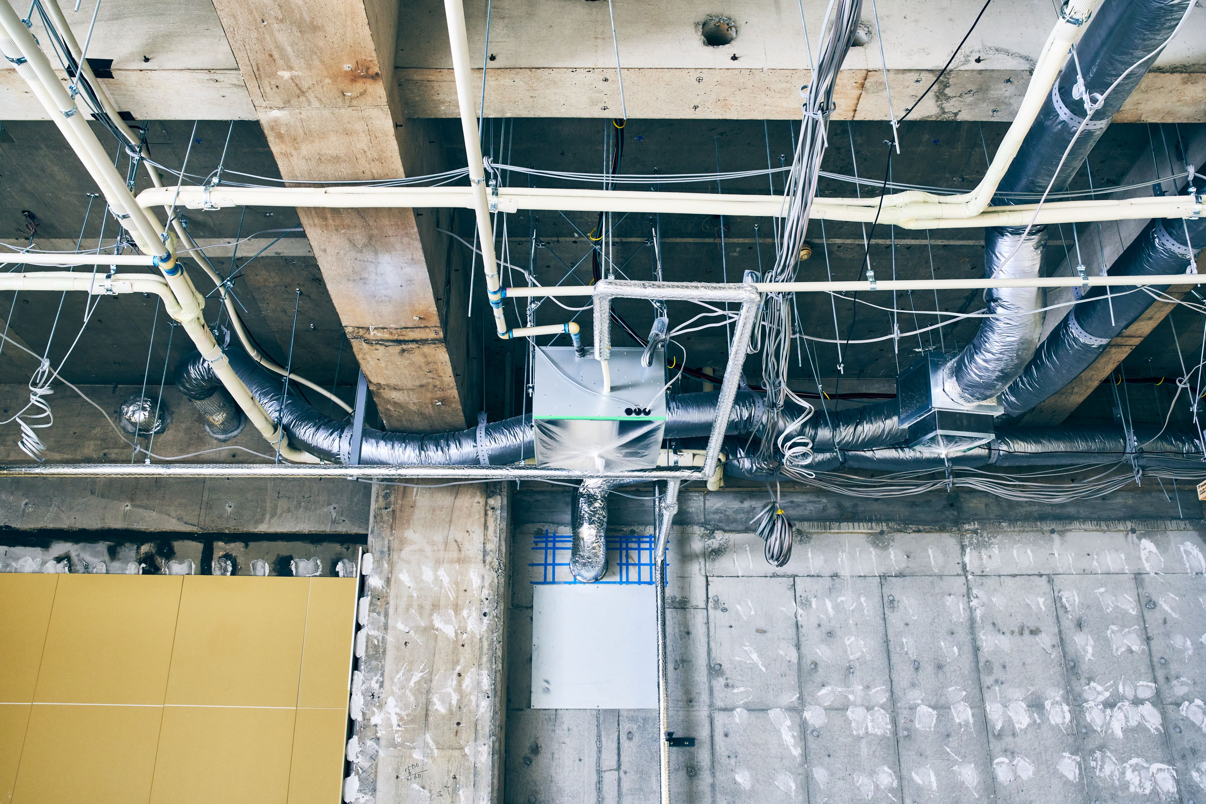  X線で透過して躯体中の鉄筋の位置（青いテープ）を調査し、壁にダクト用の穴を開けた部分