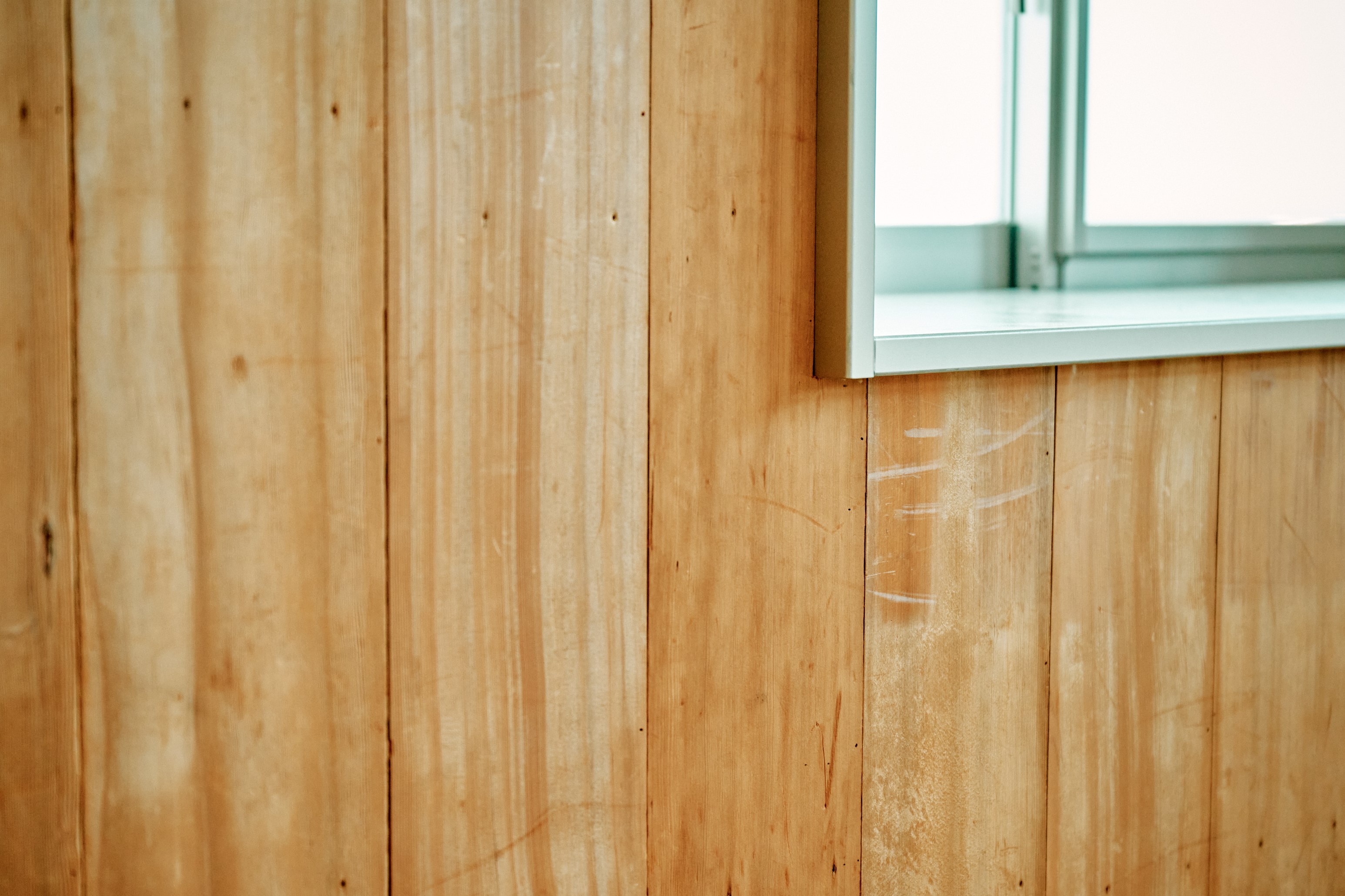 かすかに傷跡が残る旧道場の床材を壁板に再利用